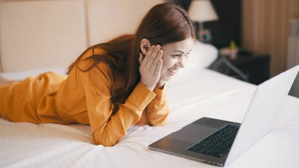 Emotionele vrouw liggend in bed in de voorkant van laptop internet technologie communicatie werk — Stockfoto