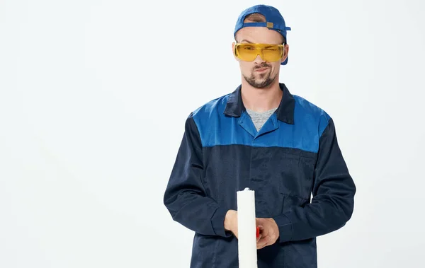 Hombre reparación pintura rodillo azul traje y gorra gafas — Foto de Stock