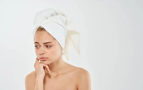 Mooie vrouw met handdoek op het hoofd kale schouders lichte achtergrond bijgesneden uitzicht — Stockfoto