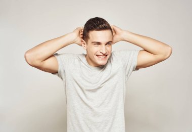 Beyaz tişörtlü bir adam elleri ve duyguları ile hareket eder stüdyo ışığı arka planı