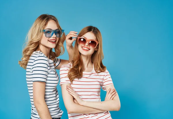 Femmes en t-shirts rayés lunettes de soleil joie émotion fond bleu — Photo