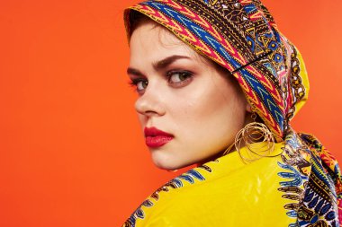 Çok renkli sarıklı, kırmızı dudaklı kadın. Çekici görünüyor.