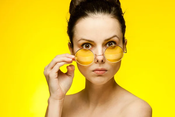 魅力的なブルネットの黄色のメガネ裸の肩スタジオ — ストック写真