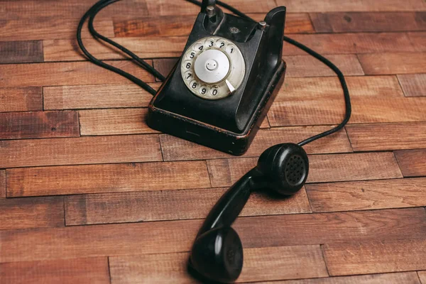 Retro telephone black on a wooden floor classic — Stock Photo, Image