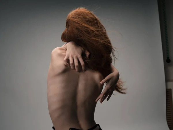 Una mujer delgada se toca a sus espaldas con sus manos con el modelo de la emoción —  Fotos de Stock