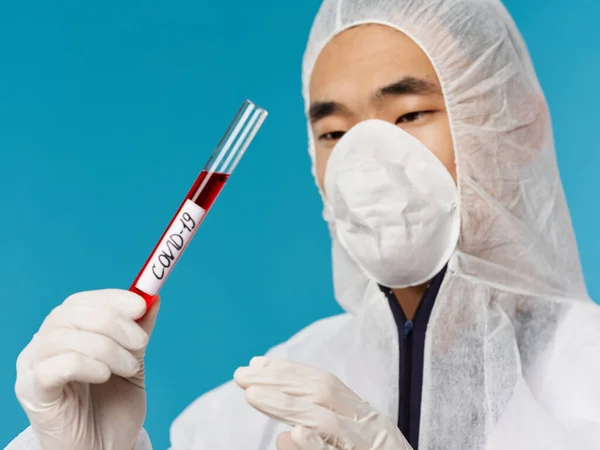 Manlig laboratorieassistent blodprov covid-19 närbild blå bakgrund — Stockfoto