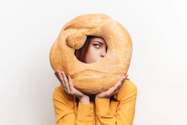 Loaf flour product and women in yellow shirt in the background light background — Stock Photo, Image