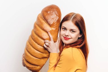 Bir somun ekmeğe sarılan mutlu kadın ürün hafif arka planda kırpılmış manzara