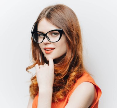 Turuncu elbiseli ve gözlüklü güzel kadın makyaj portresi.