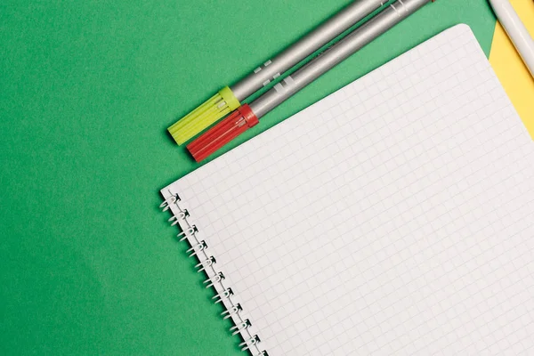 Офісне приладдя ручки та блокноти на жовтому зеленому фоні — стокове фото