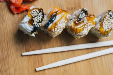 Japon mutfağı suşi sosu, yemek çubukları, zencefilli tahta.