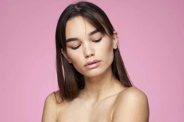 Mulher com ombros nus cuidados com o cabelo maquiagem pele limpa fundo rosa — Fotografia de Stock