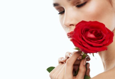 Ellerinde kırmızı gül, omuzlarında çıplak makyaj modeli olan hoş bir bayan.