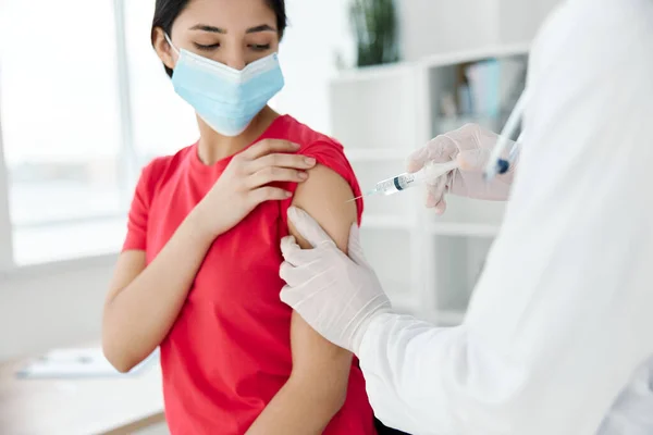 Médico que sostiene una jeringa inyectada en el hombro de una paciente covid vacunación — Foto de Stock