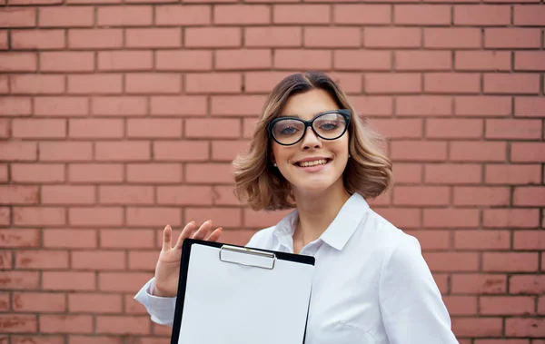 Felice donna d'affari vicino edificio con documenti in mano e occhiali sul viso vista ritagliata — Foto Stock