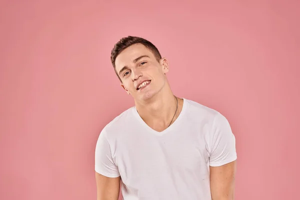 Homem emocional gesticulando com as mãos branco t-shirt rosa isolado fundo — Fotografia de Stock