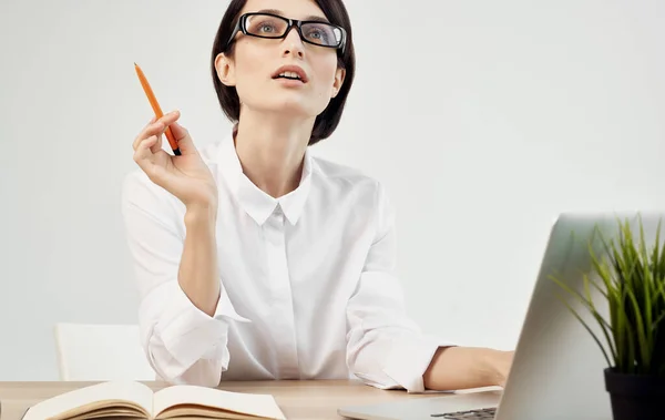Жінка сидить за своїм столом в окулярах перед керівником офісу ноутбука — стокове фото
