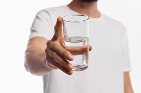 Un vaso de agua limpia en la mano de un hombre con una camisa ligera vista recortada — Foto de Stock