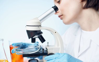 Mikroskop araştırması yapan kadın doktor laboratuvar asistanı kimyasal element aşısı.