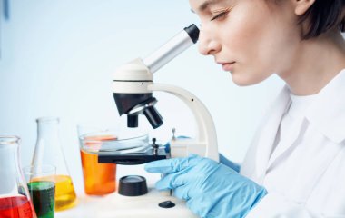 Mikroskop araştırması yapan kadın doktor laboratuvar asistanı kimyasal element aşısı.