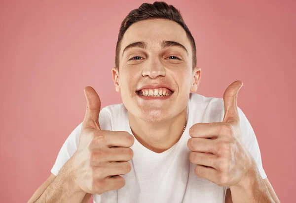 Portrait of a cheerful guy on a pink background cropped view of a white t-shirt emotions — Stock Photo, Image