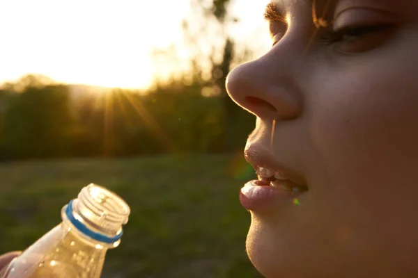 Nő iszik vizet egy műanyag palack nyáron szabadban — Stock Fotó