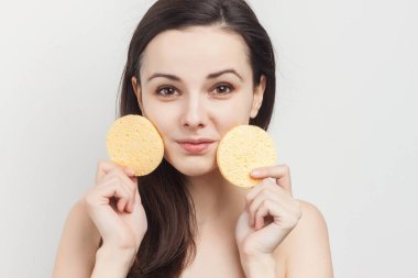 Esmer, çıplak omuzlu, yüzü süngerle kaplı.