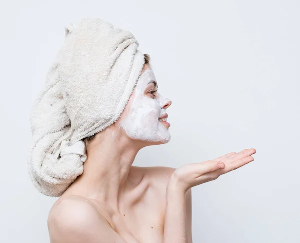 Mulher bonita com ombros nus rosto toalha de creme na cabeça pele limpa — Fotografia de Stock