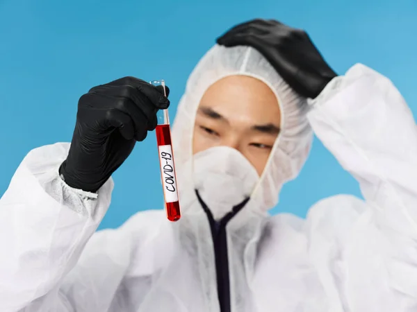 Чоловічий лабораторний технік в чорних рукавичках дослідження крові синій фон — стокове фото