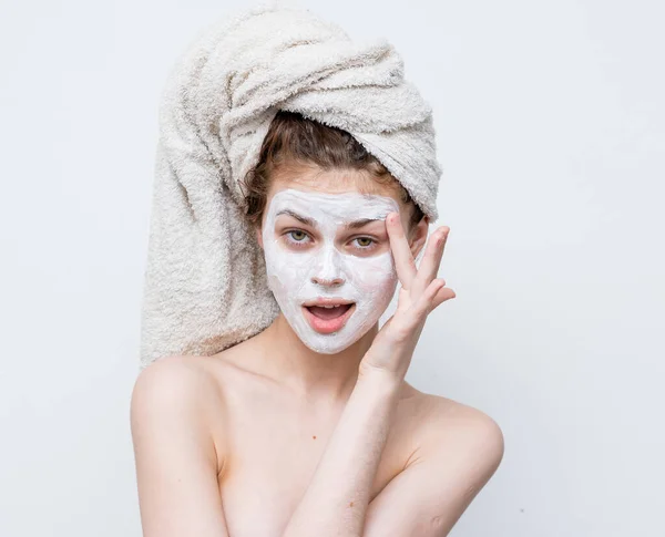 Woman with bare shoulders with a towel on her head skin care facial mask — Stock Photo, Image