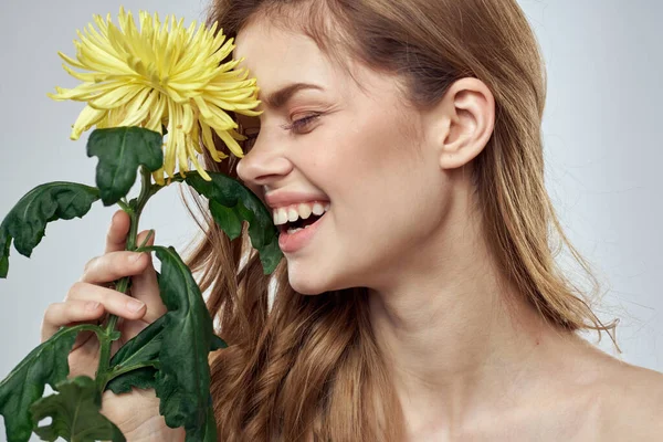 Portré egy gyönyörű nő egy sárga virág egy könnyű háttér bájos mosoly modell piros haj — Stock Fotó