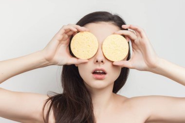 Esmer, çıplak omuzlu, yüzü süngerle kaplı.