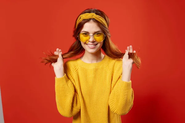 Vacker kvinna i gul tröja med hår känslor beskärda visa röd bakgrund — Stockfoto
