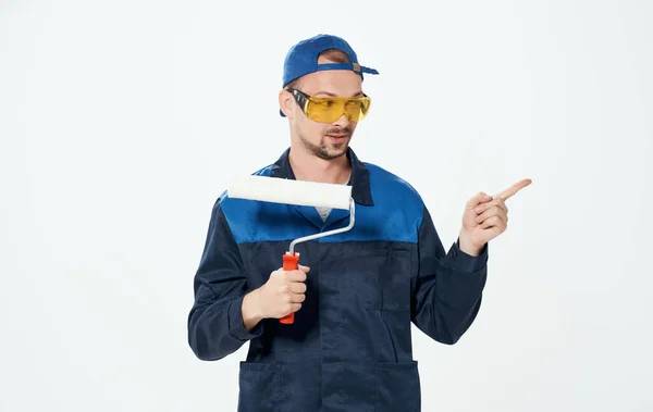 Férfi javítása festék görgő kék öltöny és sapka szemüveg — Stock Fotó