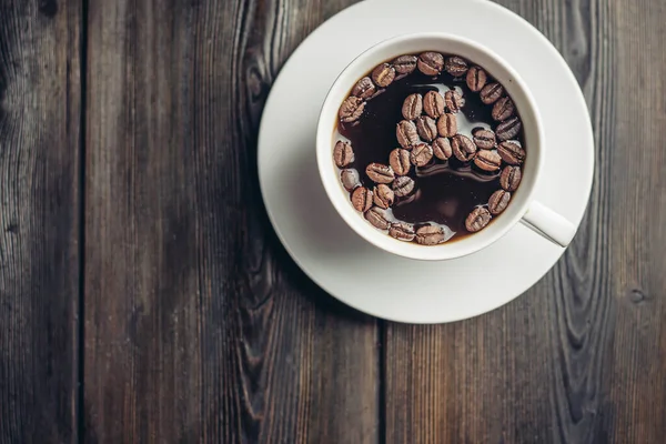 Bebida aromática em copos grãos de café mesa de madeira café da manhã — Fotografia de Stock