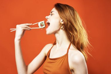 Neşeli kızıl saçlı kadın sushi diyet yapıyor. Yakın plan eğlence.