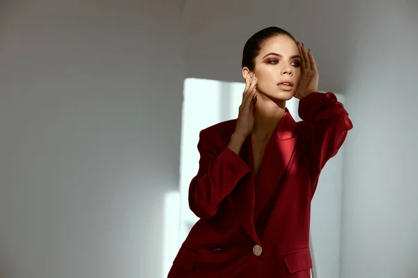 Mujer con sombra de ojos y peinado en su cabeza chaqueta roja fondo oscuro vista recortada —  Fotos de Stock