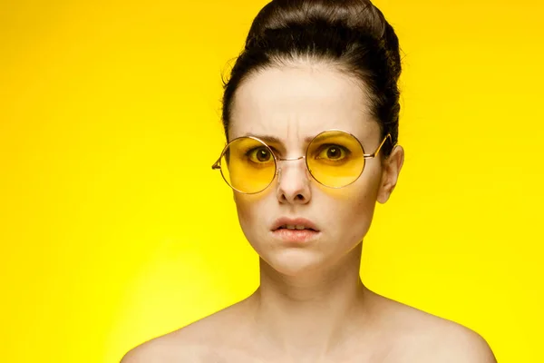 Güzel kadın eğlenceli sarı gözlükler çıplak omuzlar izole edilmiş arka plan — Stok fotoğraf