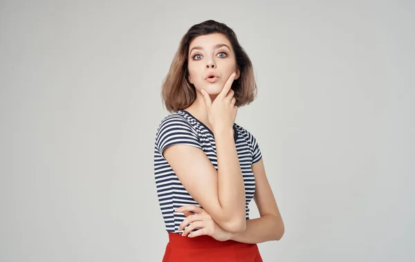 Jolie femme modèle en t-shirt rayé geste avec les mains sur fond gris Espace de copie — Photo