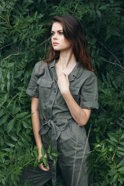 Model tree leaves outdoor walks green overalls against the background
