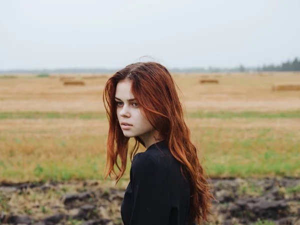 Portré egy vörös hajú nő egy fekete ruhát a területen a természet kivágott kilátás — Stock Fotó