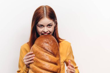 Somun ekmekli ve sarı gömlekli bir kadın. Kırmızı saçlı.