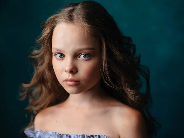 Imádnivaló lány göndör haj csupasz vállak kék sundress sötét háttér — Stock Fotó