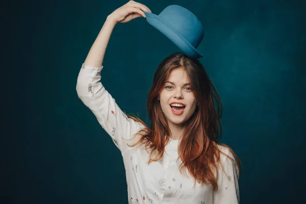 头戴帽子，头戴蓝色背景，穿着衬衫的精力充沛的女人 — 图库照片
