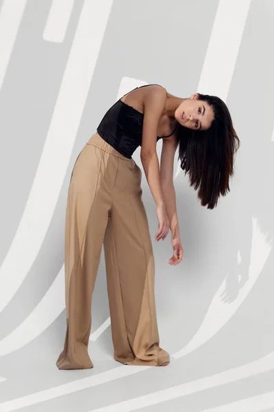 Lydia w beżowych spodniach grube włosy kosmetyki model pokój — Zdjęcie stockowe