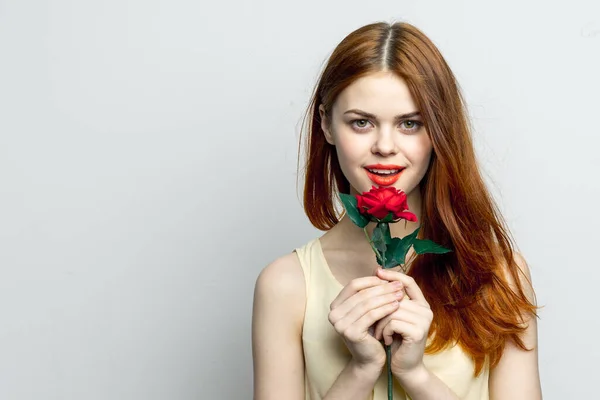 手にバラの花を持つ笑顔の女性魅力的な赤い唇の魅力的な外観孤立した背景 — ストック写真