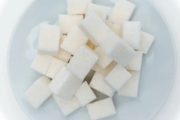 Geraffineerde suiker snoep calorieën op een plaat lichte achtergrond — Stockfoto