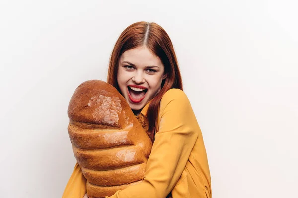 Una mujer alegre con maquillaje brillante abraza un pan con sus manos —  Fotos de Stock