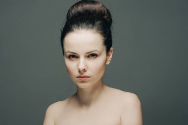 Esmer, çıplak omuzlu. Duyguları yüzünden okunuyor.