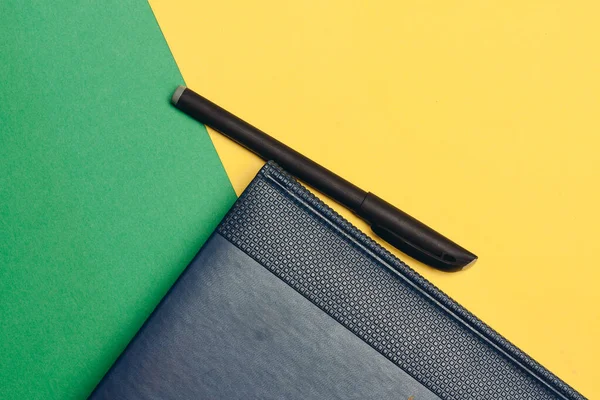 Sarı yeşil arka plan çalışma ofisinde mavi defter ve çok renkli kalemler. — Stok fotoğraf